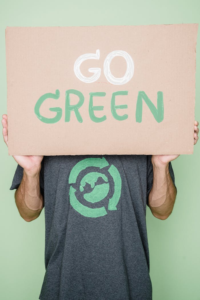 trusted-partner Person holding a 'Go Green' sign promoting environmental sustainability.